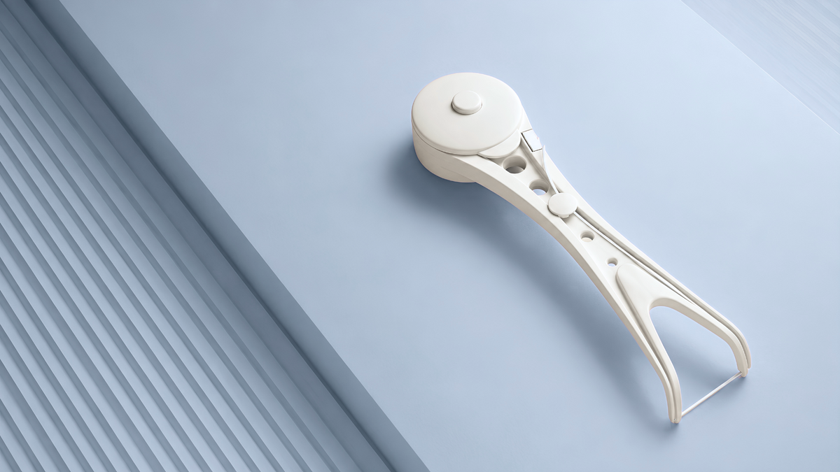 White reusable Flossy on a light blue surface with diagonal architectural lines